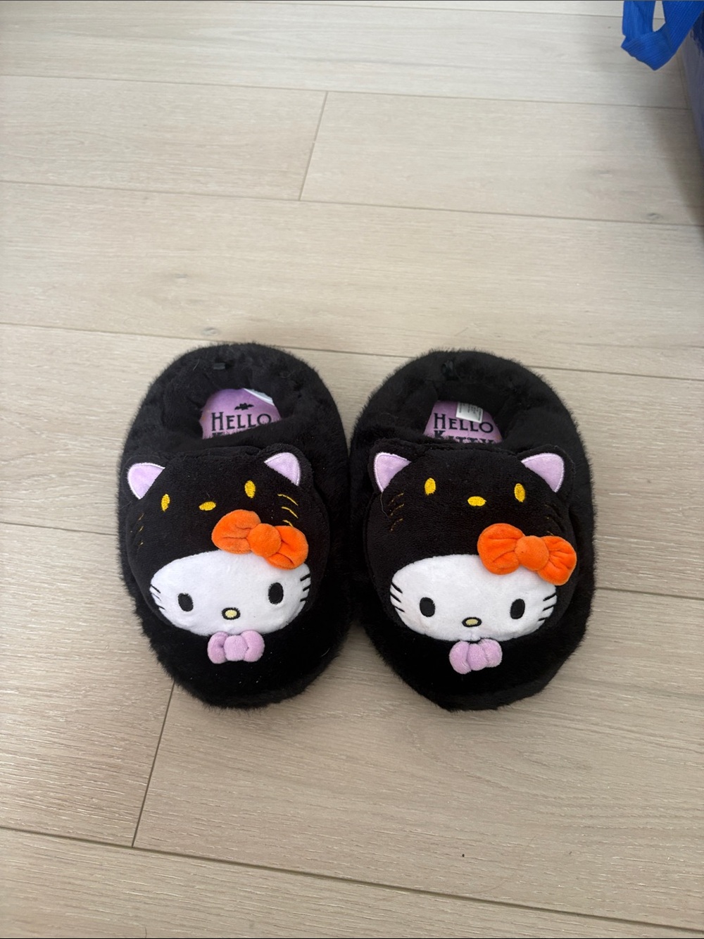 Sanrio Black Hello Kitty Plush Slippers with Orange Bow and Pink Accents